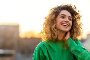 Woman standing in sunlight with a peaceful smile, symbolizing the benefits of Dry January.