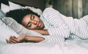 Woman sleeping soundly, symbolizing learning how to fix your sleep and create a consistent sleep routine