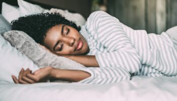 Woman sleeping soundly, symbolizing learning how to fix your sleep and create a consistent sleep routine